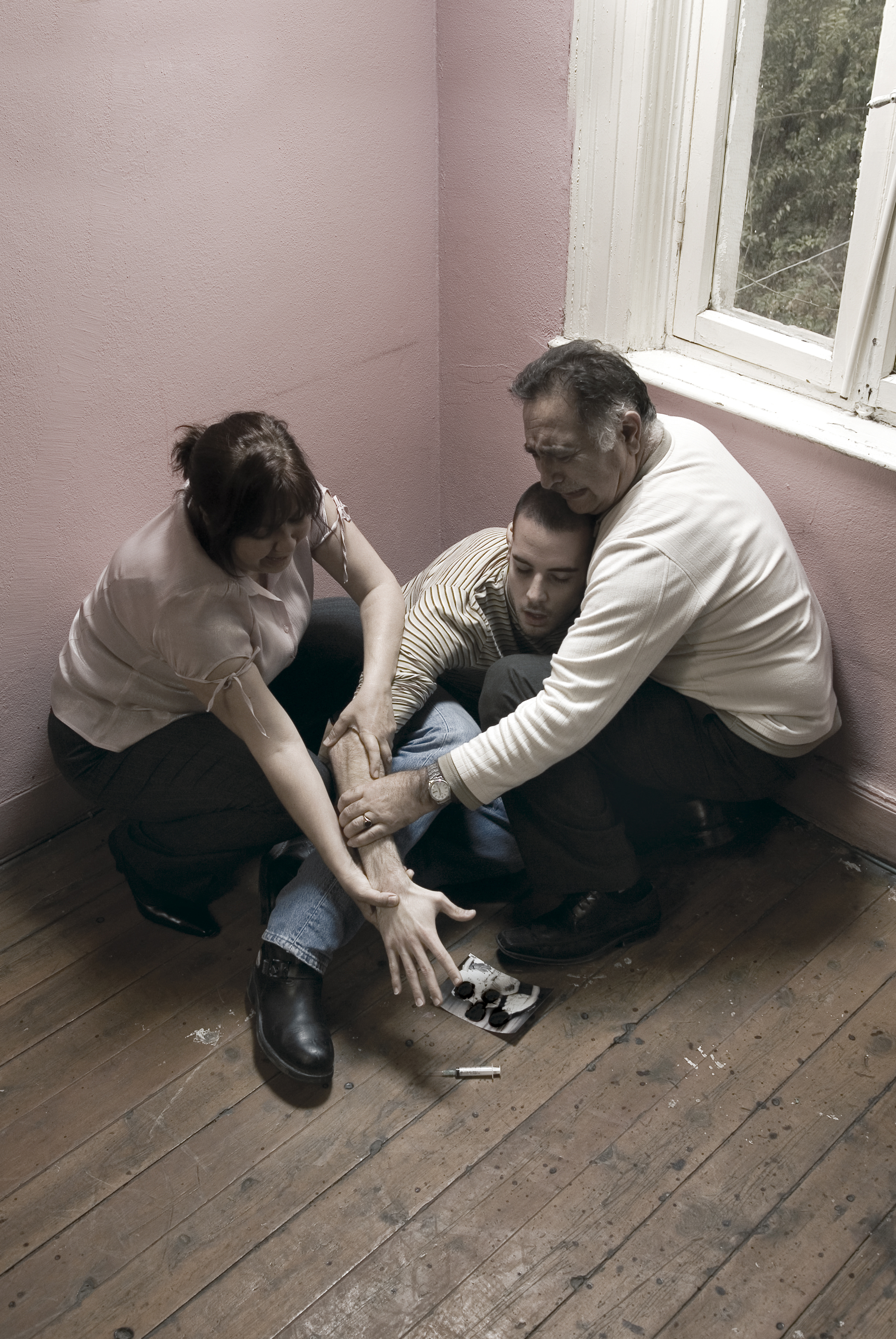 Two Parents Hold Young Man's Arm From Reaching Syringe